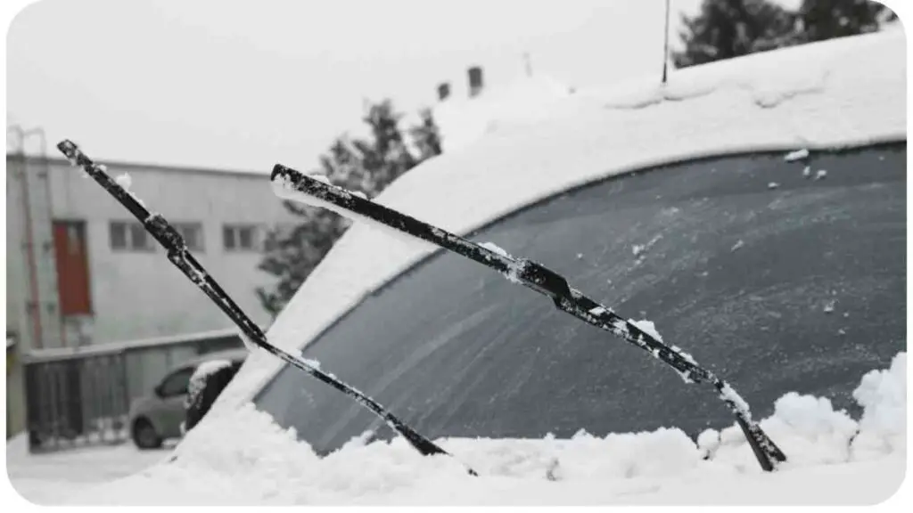 the windshield wipers of a car are covered in snow